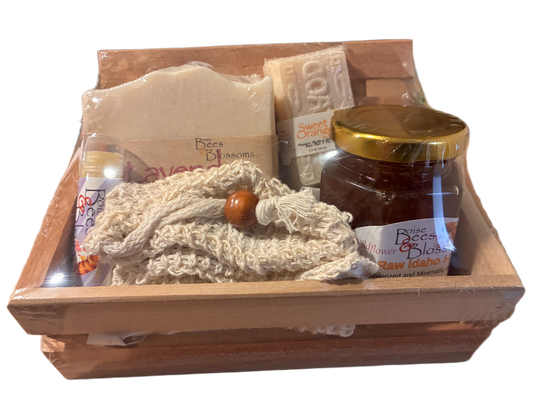 Wooden basket with natural products including soap, honey, and a cloth on a white background